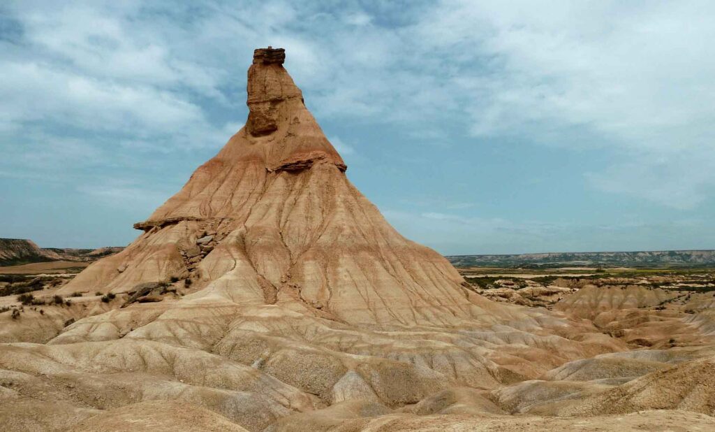 Große erodierte Felsformation Castildetierra in der trockenen Landschaft der Bardenas Reales unter blauem Himmel.