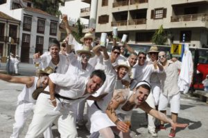 Lachende Gruppe weiß gekleideter Männer mit Puderdosen posiert beim Karneval in Santa Cruz de La Palma.