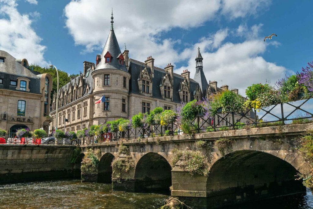 Historische Gebäude und eine blumengeschmückte Steinbrücke am Fluss Odet in Quimper in der Bretagne.