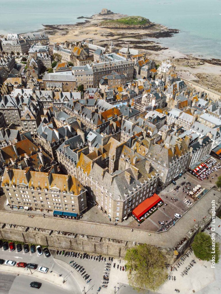 Armor-Lux – eine bretonische Mode-Erfolgsgeschichte 20 Luftaufnahme der Altstadt von Saint-Malo mit Stadtmauer, Schieferdächern und der Insel Grand Bé an der Küste der Bretagne.
