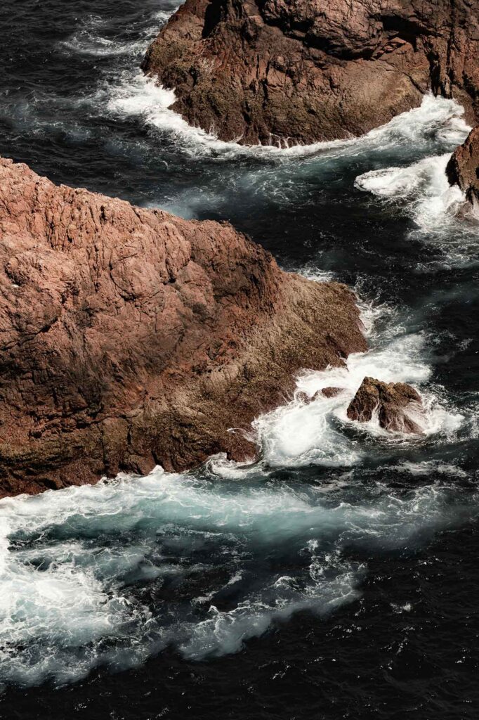 Brandung des Atlantiks prallt gegen dunkle Felsen an der Küste der Berlengas in Portugal.