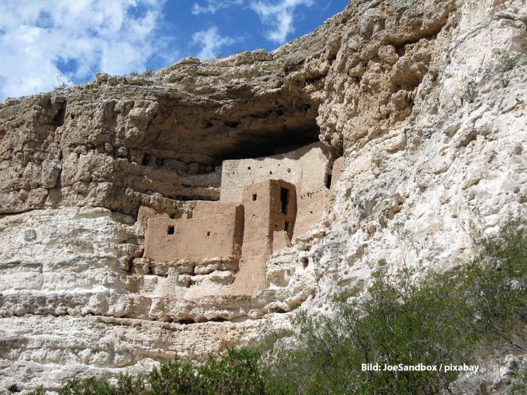 Klippenwohnung von Montezuma Castle in Arizona, ein gut erhaltenes prähistorisches Pueblo-Bauwerk, eingebettet in eine Felswand unter blauem Himmel.