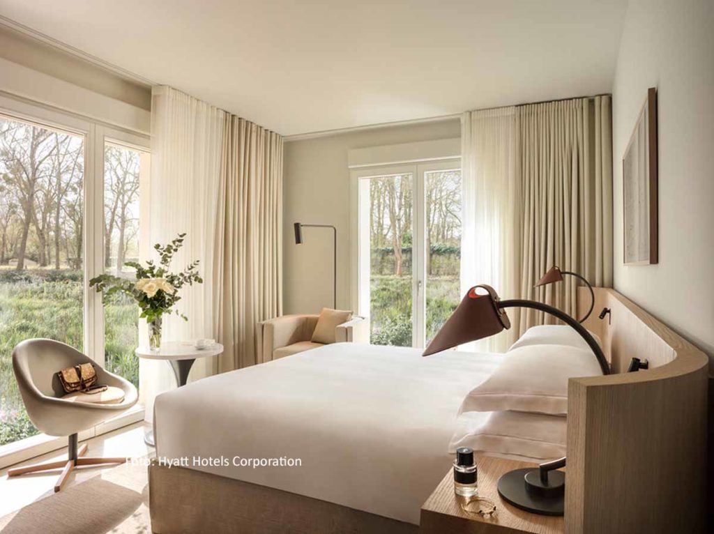 Eckzimmer mit Bett und zwei Fensterfronten