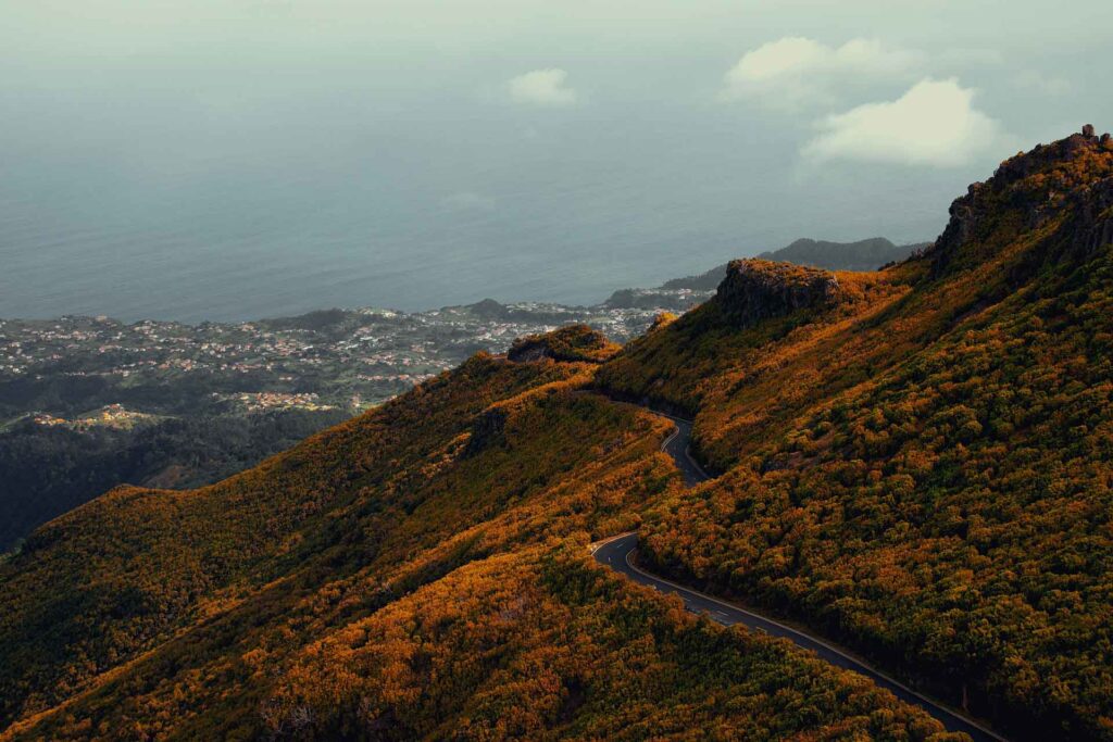 Die Atlantikinsel Madeira in der Übersicht 19 Serpentinenstraße im Bergland von Madeira mit Blick über bewaldete Hänge bis zum Atlantik