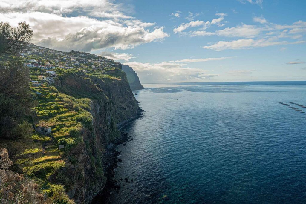 Die Atlantikinsel Madeira in der Übersicht 18 Steilküste auf Madeira mit terrassierten Hängen, Küstendorf und weitem Blick über den Atlantik