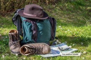 Rucksack, Wanderschuhe, Hut, Kompass und Karte