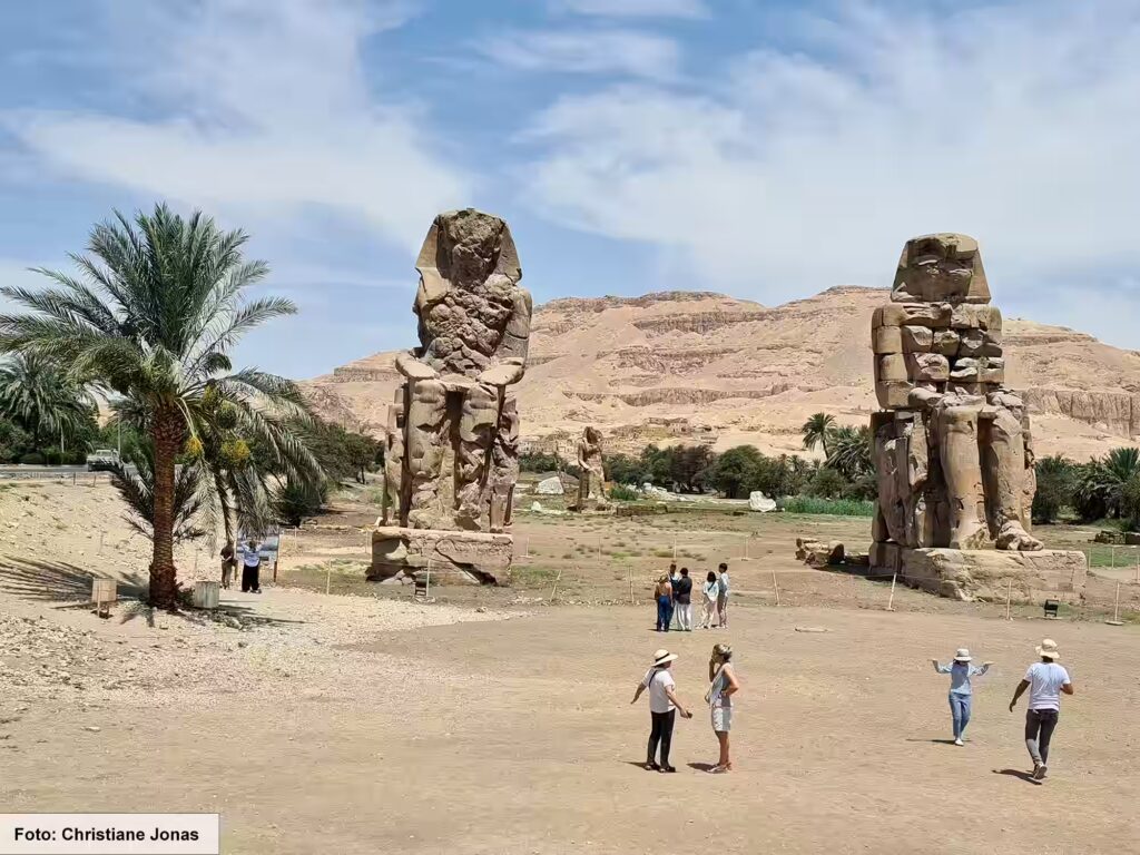 Eine Nil-Kreuzfahrt in Ägypten ist ein einmaliges Erlebnis 4 Touristen schauen die Kolosse von Memnon an