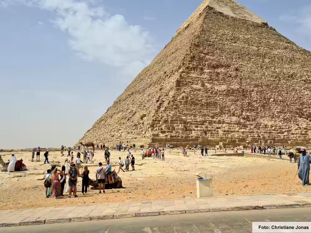 Eine Nil-Kreuzfahrt in Ägypten ist ein einmaliges Erlebnis 54 Im Hintergrund befindet sich die Pyramide, im Vordergrund viele Touristen und einige Kamele