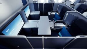 Business-Class-Suite von Discover Airlines mit hohen Wänden, ausziehbarem Tisch und zwei gegenüberliegenden Monitoren für gemeinsames Reisen.
