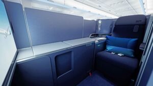 Geschlossene Business-Class-Suite bei Discover Airlines mit viel Stauraum, breitem Sitz und „Ocean Blue“-Polsterung.