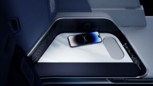 Detailansicht der seitlichen Ablage eines Business-Class-Sitzes bei Discover Airlines mit Bedienfeld, Steckdosen und Smartphone.