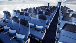Economy-Class-Kabine von Discover Airlines im „Ocean Blue“-Design mit blauen Sitzen, Kopfstützen und Mittelgang in einer A330.