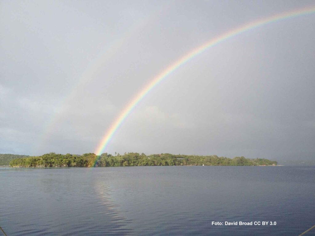 Regenbogen vor einer Insel