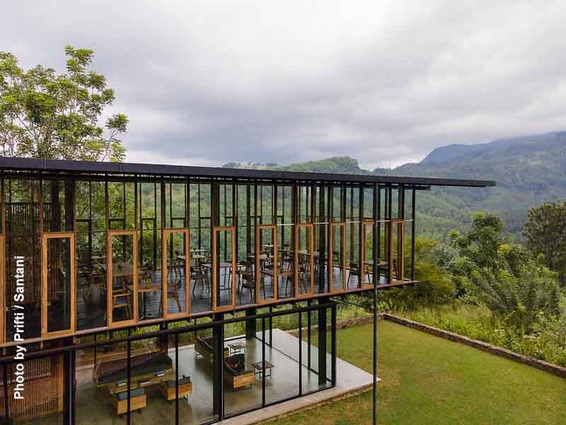Glaspavillon des Restaurants im Santani Wellness Kandy mit Panoramablick auf grüne Berge und Wald.