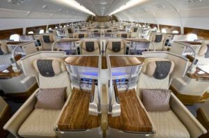 Emirates A380 Sitzplätze und Services - die Fotos 54 Business-Class-Kabine im Emirates Airbus A380 mit breiten Sitzen, Holzelementen und indirekter Beleuchtung.