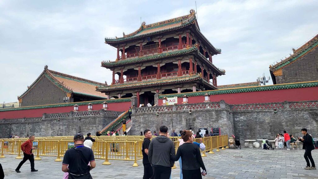 Kaiserpalast von Shenyang – Die „Verbotene Stadt“ des Nordens erleben 6 Großes Palasttor mit dreistöckigem Pavillonaufbau und gelb glasiertem Dach über roter Mauer; Besucher davor.