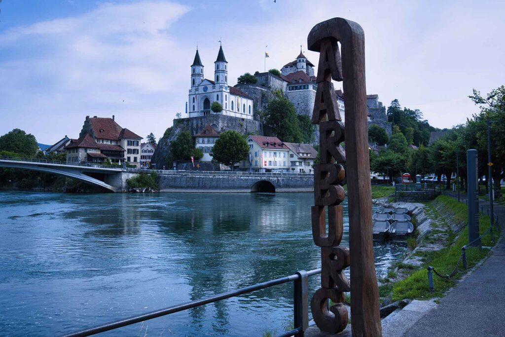Durch eiskaltes Wasser und Stromschnellen schwimmen 11 Blick auf Aarburg mit Festung und Kirche an der Aare, idyllische Flusslandschaft in der Schweiz