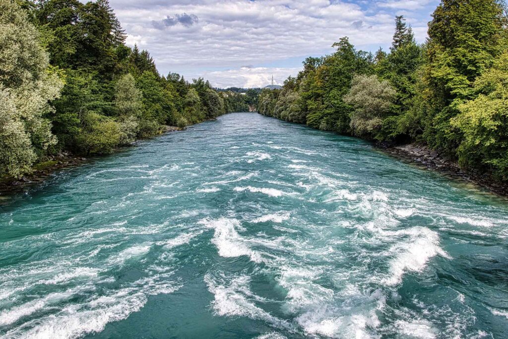 Durch eiskaltes Wasser und Stromschnellen schwimmen 9 Wilde Strömung der Aare bei Uttigen, umgeben von dichtem Grün