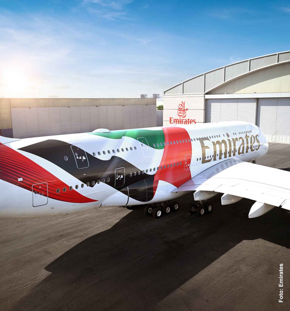 Emirates Airbus A380 mit Sonderlackierung in den Farben der Vereinigten Arabischen Emirate auf dem Vorfeld in Dubai vor einem Wartungshangar.