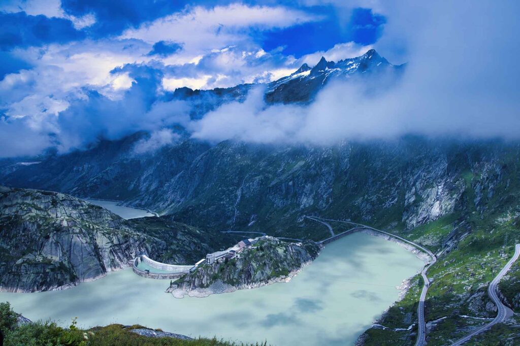 Durch eiskaltes Wasser und Stromschnellen schwimmen 3 Blick auf den Grimselsee mit Staumauern und dramatischer Wolkenkulisse in den Alpen