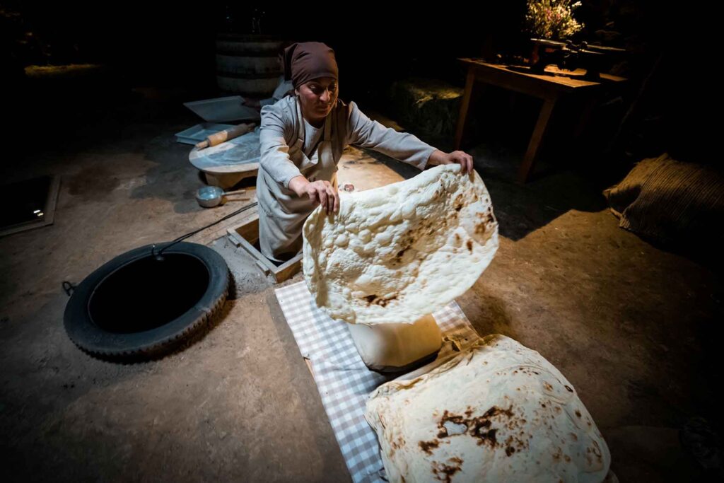 Armenien – Das unterschätzte Juwel im Kaukasus 9 Armenische Frau backt traditionelles Lavash-Fladenbrot im Tandoor-Ofen.