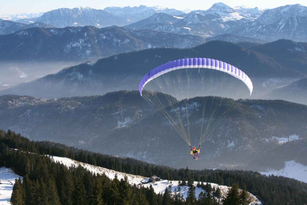 Alpenabenteuer: Fliegen über Salzburg und den Zeller See 3 Person fliegt mit Gleitschirm über die Berge