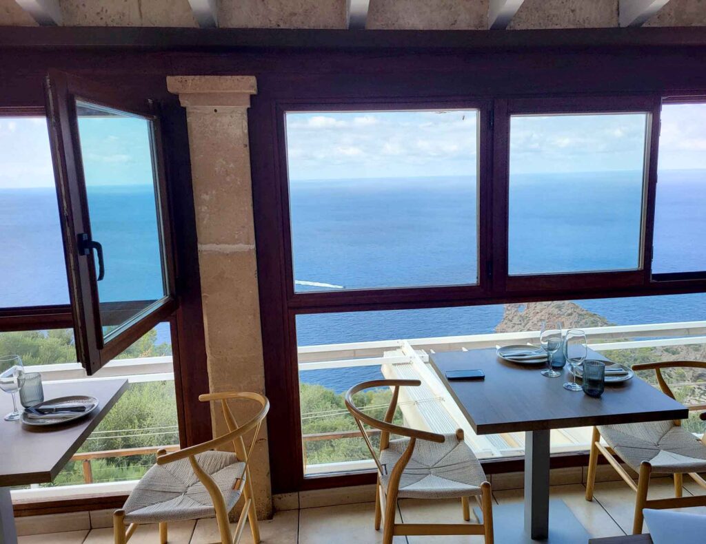 Sa Foradada – die durchlöcherte Halbinsel Mallorcas 4 Innenraum eines Restaurants bei Sa Foradada auf Mallorca mit gedeckten Tischen und weitem Blick auf das Mittelmeer.