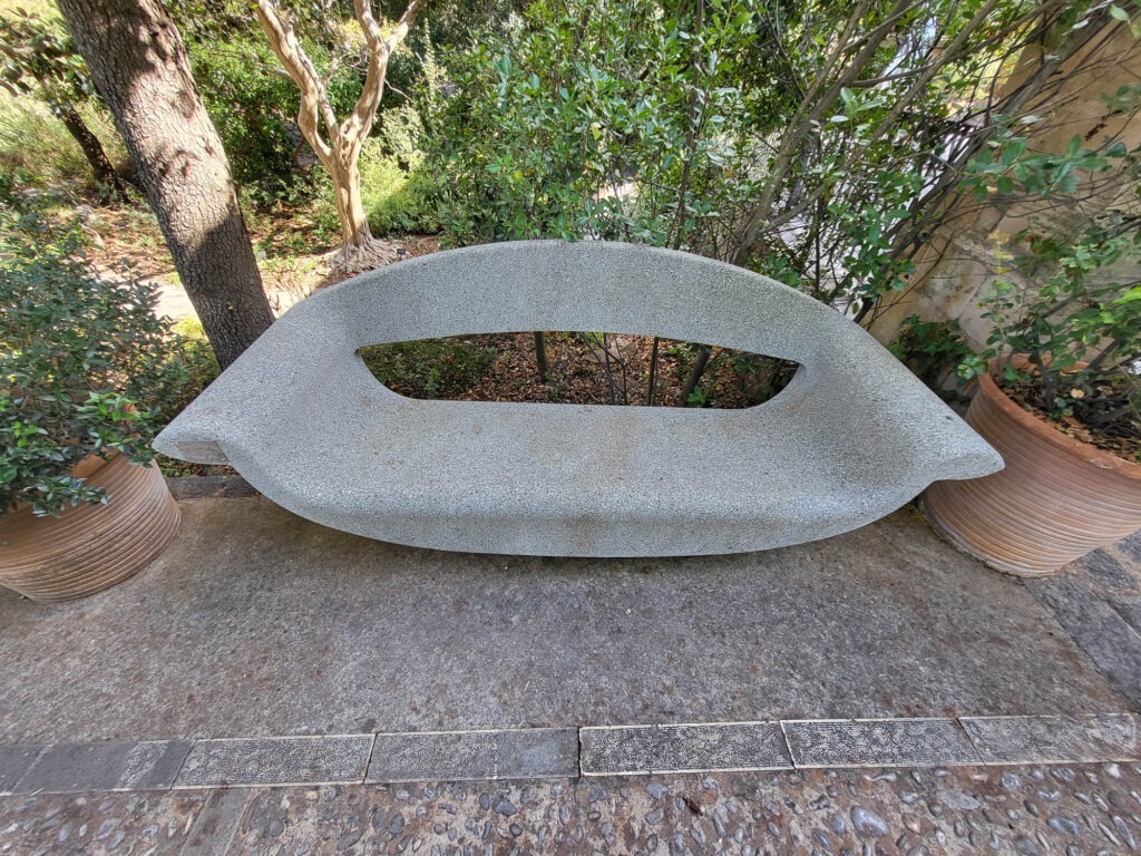 Botanischer Garten und Museum in Sóller – Natur erleben auf Mallorca 7 Steinbank mit futuristischem Design im Botanischen Garten von Sóller auf Mallorca, umgeben von mediterranen Pflanzen