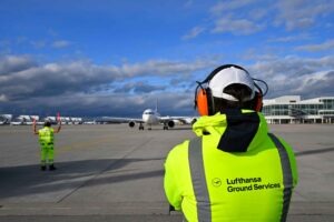 Ein Mitarbeiter des Lufthansa Ground Service blickt auf das Flugfeld