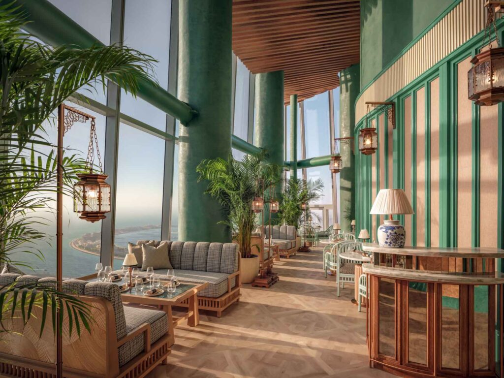 Helle Lounge mit hohen Panoramafenstern im Ciel Dubai Marina, eingerichtet mit eleganten Sofas, Pflanzen und Laternen, mit weitem Blick über Dubais Küstenlinie.