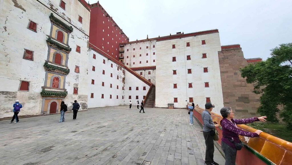 Großer Innenhof des Putuo Zongcheng Tempels mit massiven weißen und roten Klostermauern