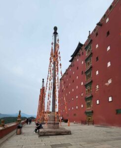 China: „Kleiner Potala“ von Chengde - ein imperiales Meisterwerk zwischen den Welten 25 Gebetsfahnen vor der roten Außenmauer des Putuo Zongcheng Tempels in Chengde