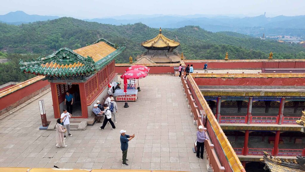 Besucher auf der Aussichtsterrasse des Putuo Zongcheng Tempels mit Blick auf die Berglandschaft