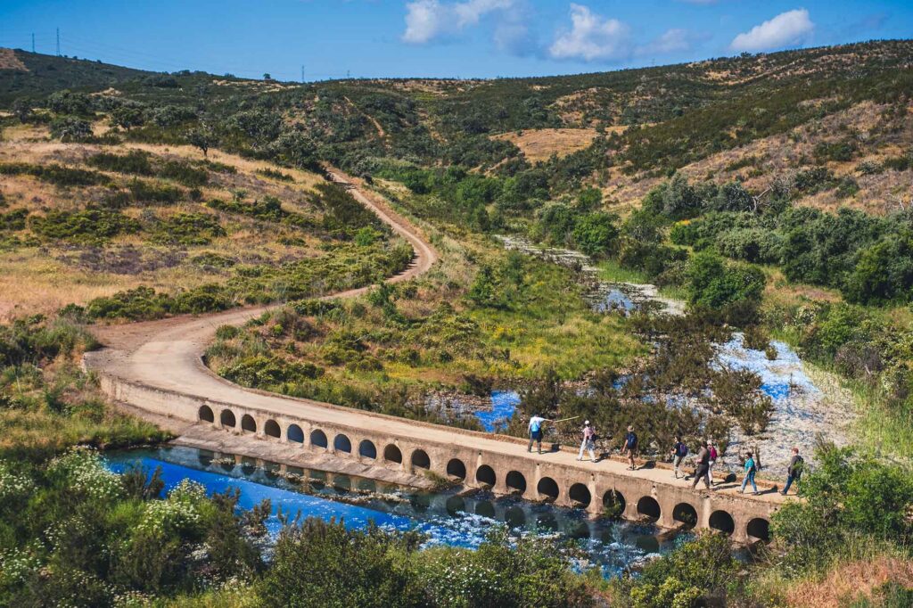 Wanderer überqueren auf einer Brücke einen Fluss