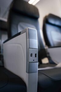Lufthansa-Sitzplatzkonfiguration und wichtige Daten zu den „Eindeckern“ - die Fotos 7 Nahaufnahme einer Armlehne in der neuen Lufthansa-Kabine. Zu sehen ist eine integrierte Ladestation mit einem Universal-Stromanschluss und einem USB-C-Port für Passagiere.