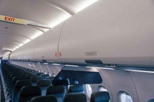 Lufthansa-Sitzplatzkonfiguration und wichtige Daten zu den „Eindeckern“ - die Fotos 6 Weitwinkelaufnahme der Flugzeugkabine mit Blick auf die geschlossenen, großräumigen Airspace-Gepäckfächer über den Sitzreihen. Ein beleuchtetes "Exit"-Schild ist im Vordergrund sichtbar.