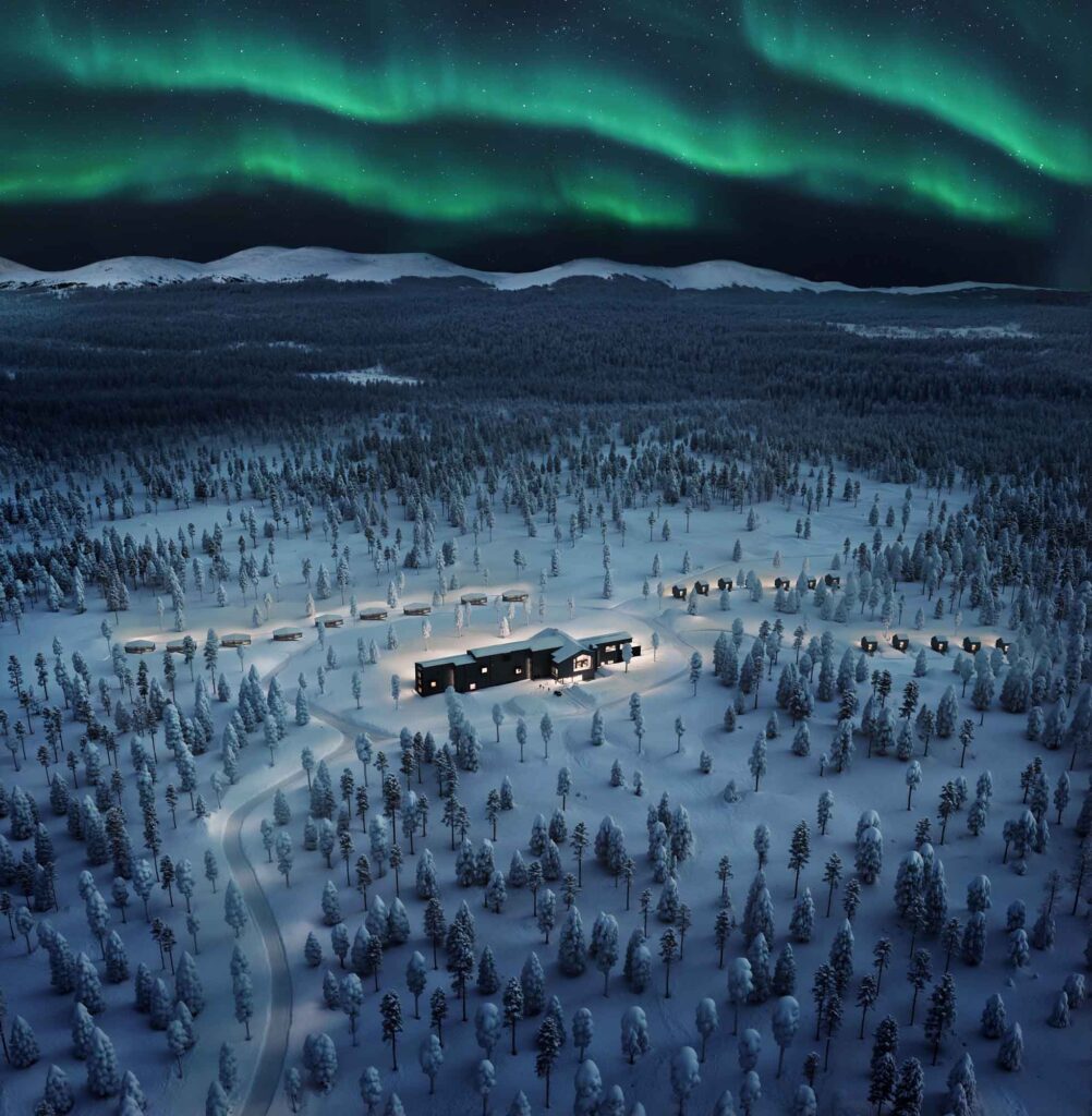 Nordlichter über verschneiter Waldlandschaft und Resort in Lakeland aus der Luft