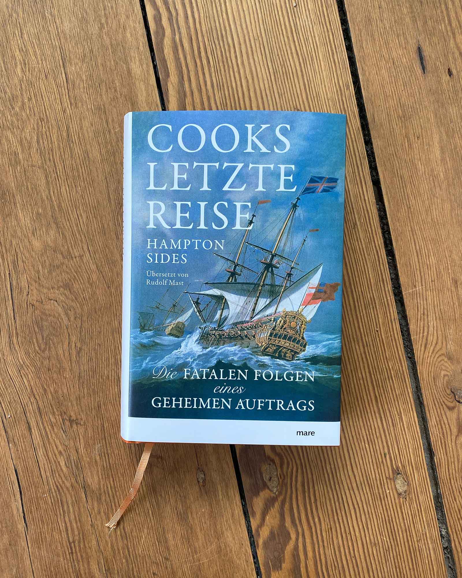 Buch-Tipp: Cooks letzte Reise – zwischen Genie, Gewalt und Grenzerfahrung 1 Buchcover von „Cooks letzte Reise“ von Hampton Sides mit Segelschiff auf stürmischer See auf Holzboden