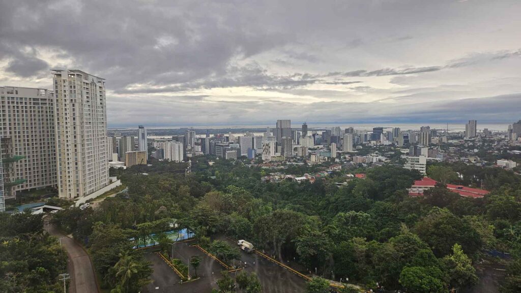 Panoramablick über Cebu City mit Hochhäusern, Parkanlagen und Küste im Hintergrund.