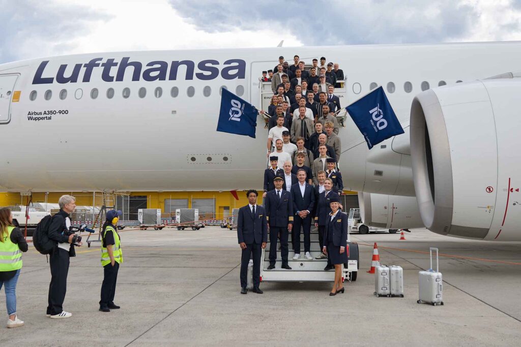 Das Fußballteam steht auf der Gangway vor dem Flugzeug