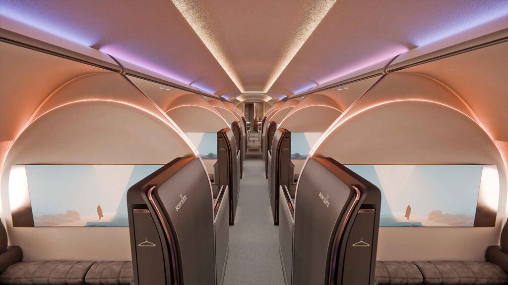 Blick durch den Mittelgang des Flugzeugs. Die Kabine ist durch hohe, bogenförmige Trennwände der Suiten geprägt, die mit indirektem Licht beleuchtet werden.