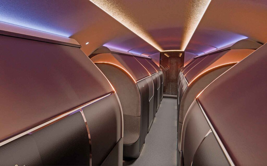 Die Flugzeugkabine bei Nacht. Die „Bow Suiten“ sind geschlossen und wirken wie beleuchtete Kokons. Das Licht ist in warmen Kupfer- und kühlen Violetttönen gehalten.