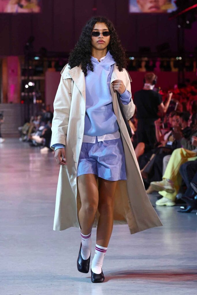 Eurowings: Was sonst noch wichtig ist 20 Model kombiniert beigen Mantel mit Hoodie und Shorts bei einer Fashion-Show auf dem Laufsteg