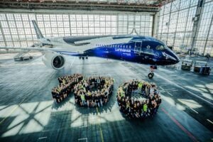 Zahlreiche mitarbeiter bilden eine 100 für einem Flugzeug mit Sonderlackierung