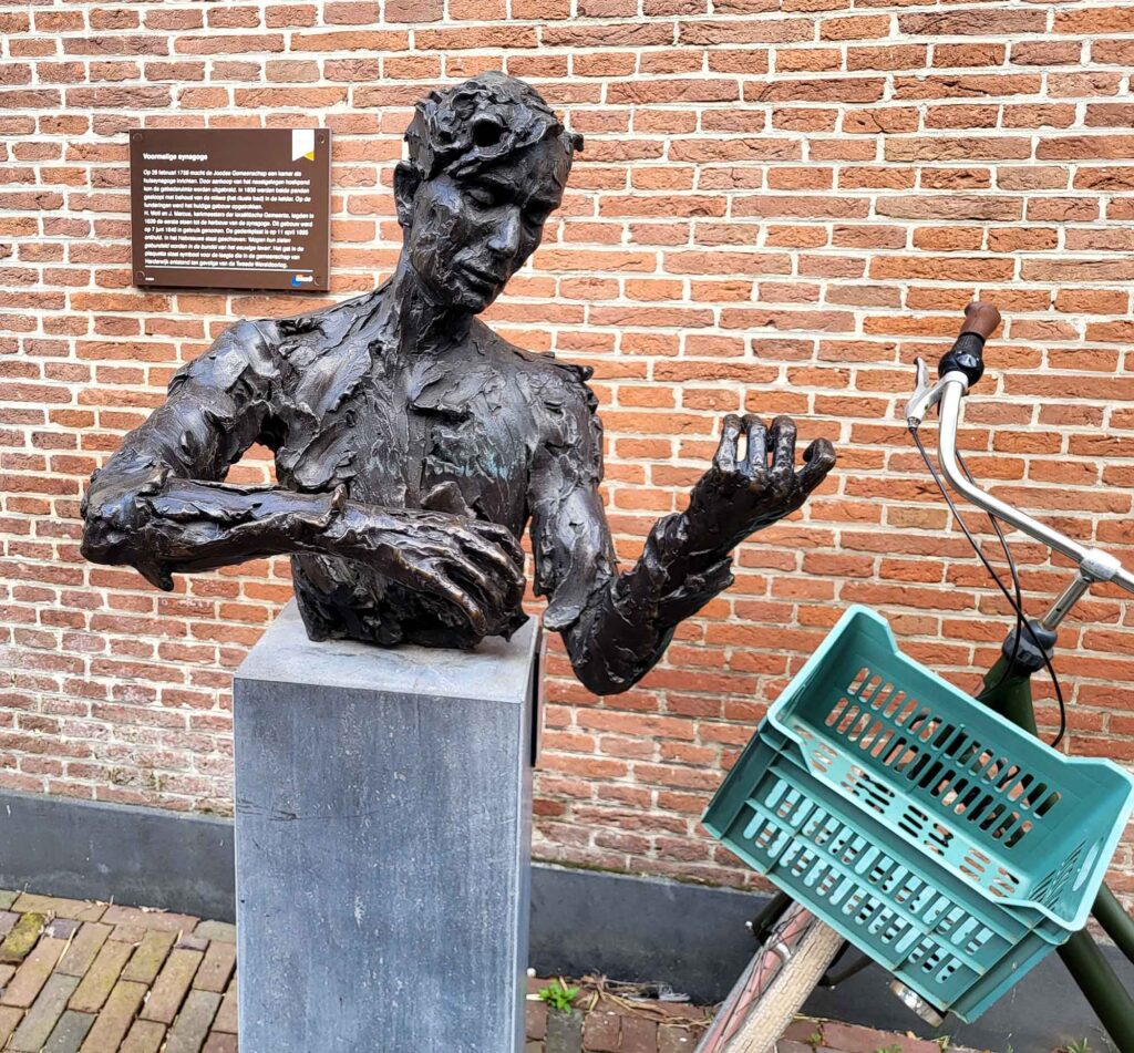 Harderwijk: Entschleunigung zwischen Hansestadt und Veluwemeer 18 Dunkle Bronzeskulptur in einer Straße der Altstadt von Harderwijk