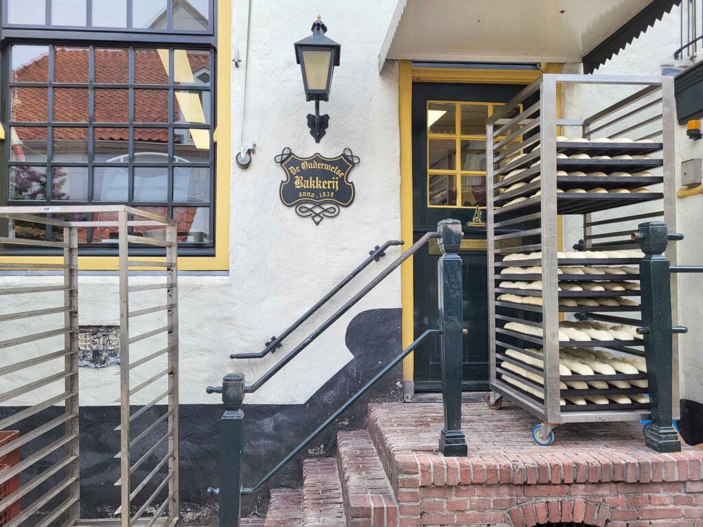 Harderwijk: Entschleunigung zwischen Hansestadt und Veluwemeer 12 Bleche mit Brotteig vor Eingang einer historischen Bäckerei in Harderwijk