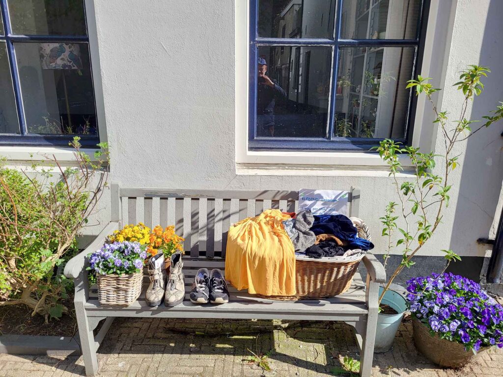 Harderwijk: Entschleunigung zwischen Hansestadt und Veluwemeer 9 Holzbank mit Kleidungskorb und Blumen vor Wohnhaus in Harderwijk