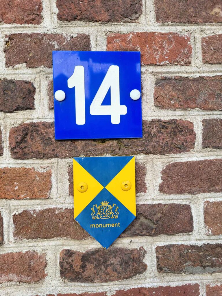 Harderwijk: Entschleunigung zwischen Hansestadt und Veluwemeer 8 Hausnummer und niederländisches Denkmalschutzschild an Backsteinwand