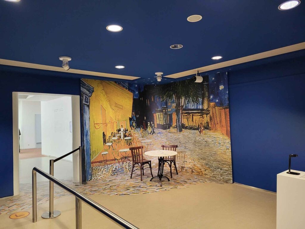 Rauminstallation mit großflächigem Wandmotiv im Stil von Vincent van Gogh und zwei Stühlen im Vordergrund