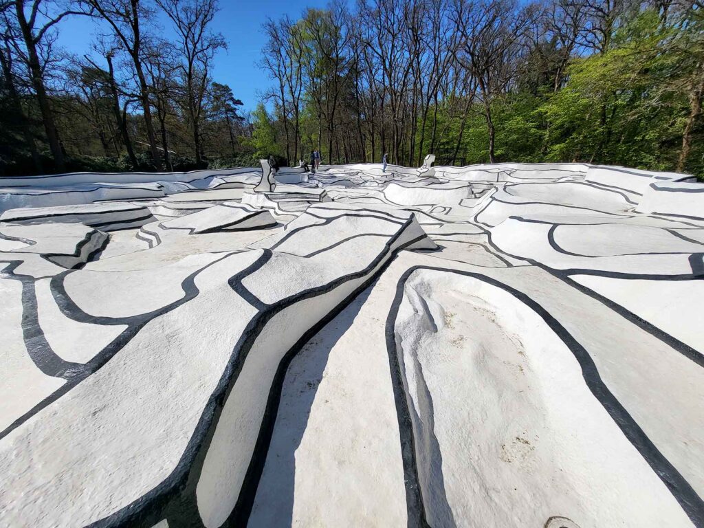 Große begehbare Installation mit weißen Flächen und schwarzen Linien, die an ein abstraktes Relief erinnert